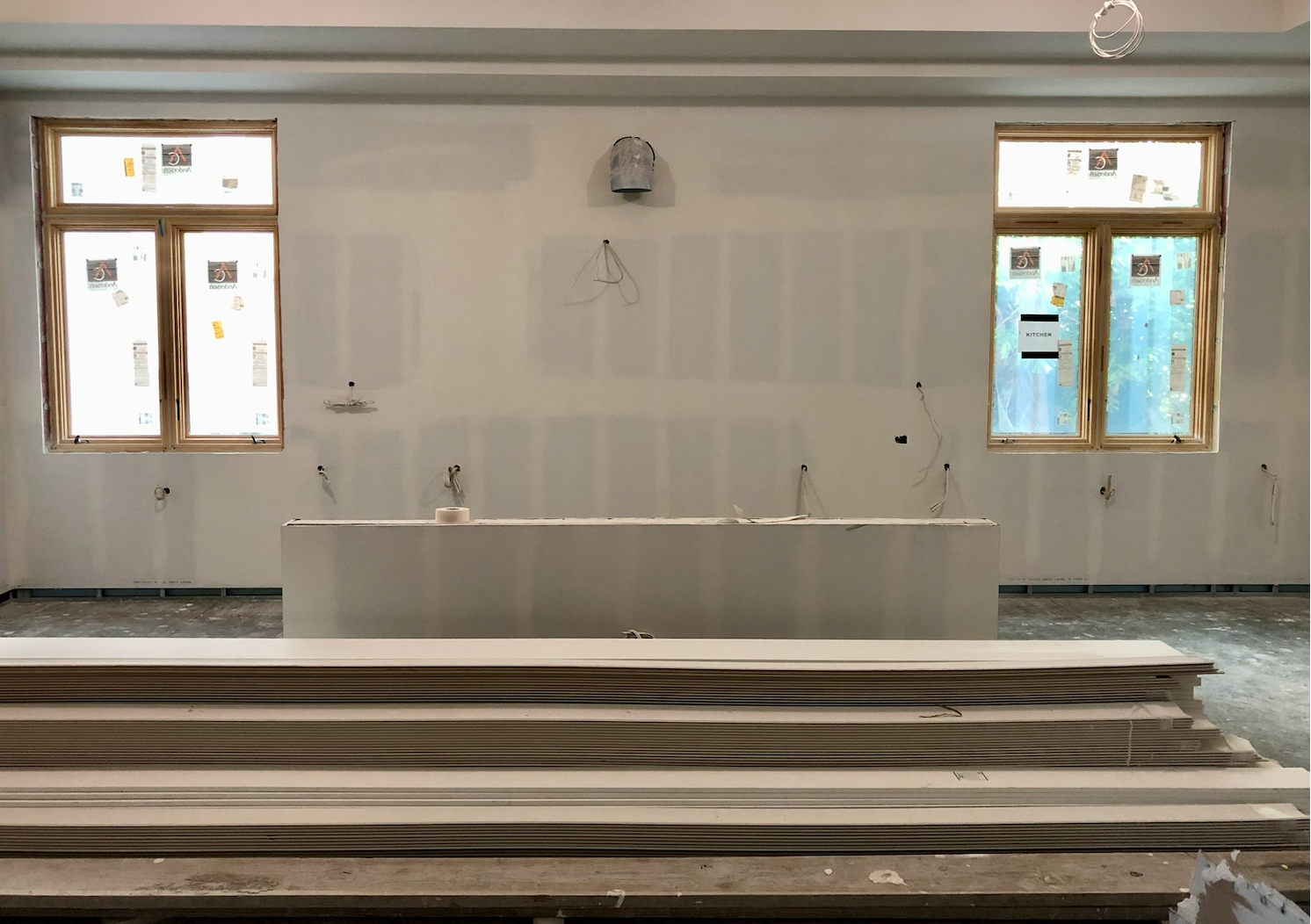 Empty white interior with a central fountain or altar and windows on both sides
