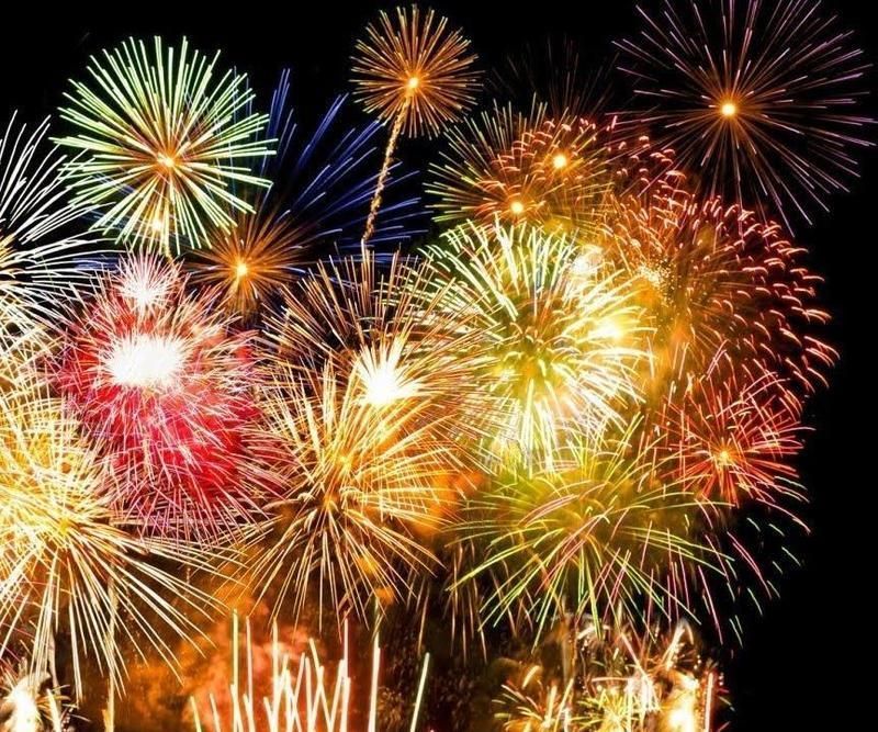 Fuochi d'artificio colorati che esplodono contro un cielo nero.