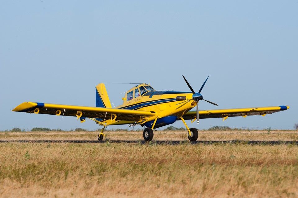 A yellow and blue plane is taking off from an airport runway.