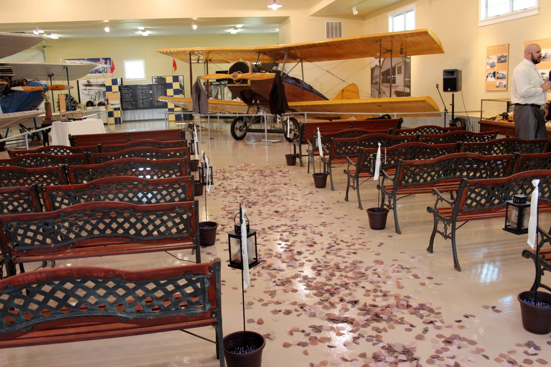 Rows of benches in a room with a plane in the background
