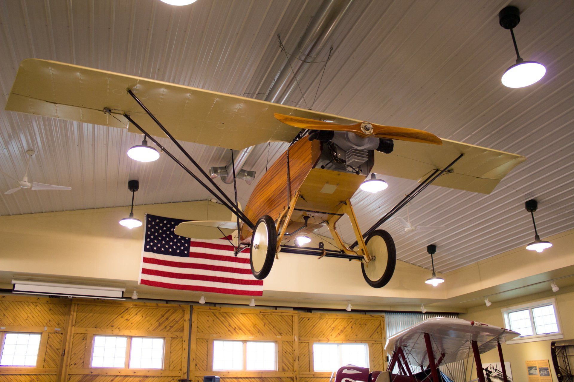 An old plane is hanging from the ceiling in a building
