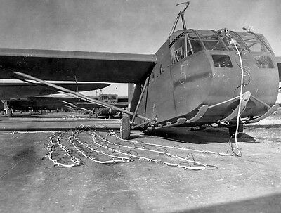 A black and white photo of a plane being towed by chains.