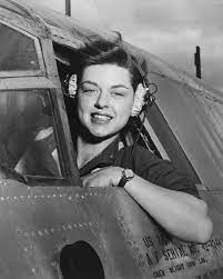 A woman is sitting in the cockpit of an airplane.