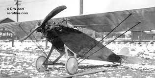 A black and white photo of a small plane in the snow.