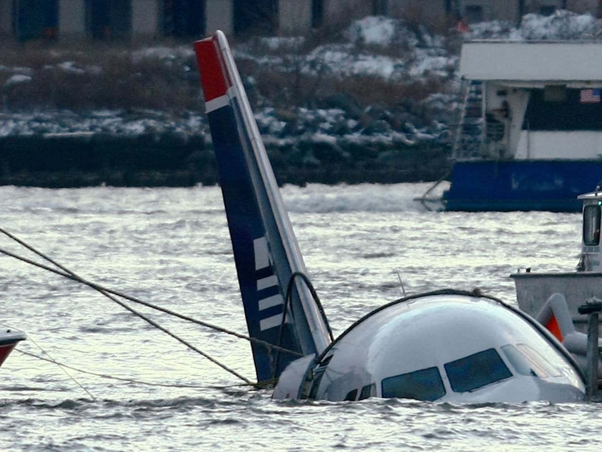 A plane is floating in the water with the tail visible