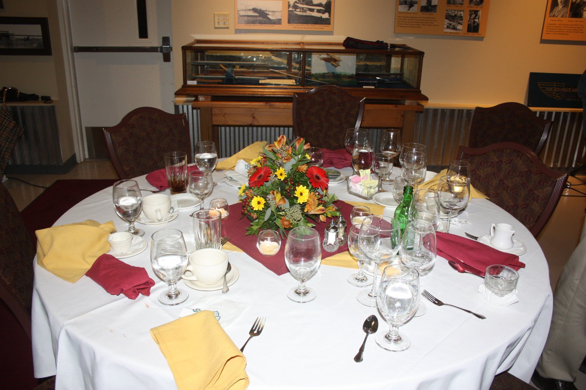 A round table with a white table cloth and flowers on it