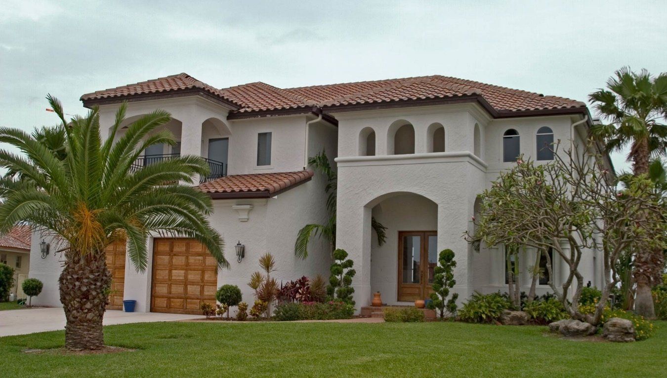 A large white house with a palm tree in front of it