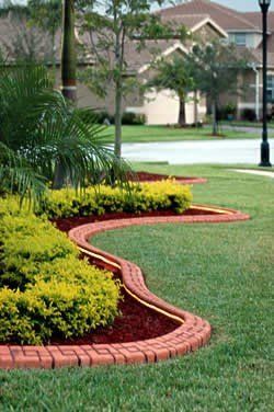 A lush green lawn with a brick curb and a brick border