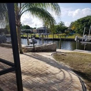 A brick walkway leading to a dock next to a body of water