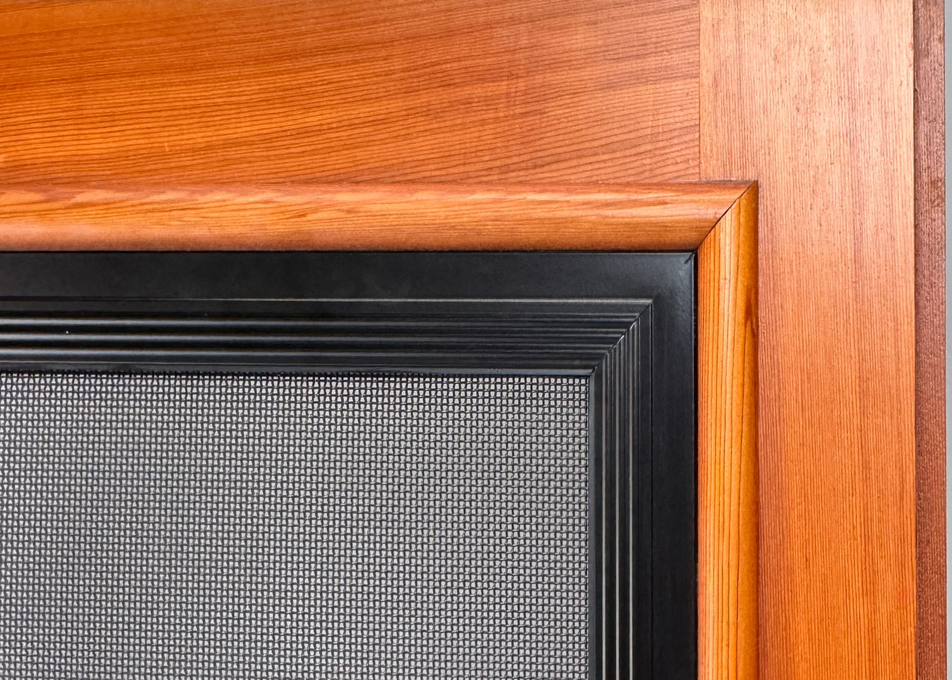 Corner of a wooden screen door with a black frame and mesh screen — Everything Screendoors & More In Wollongong, NSW