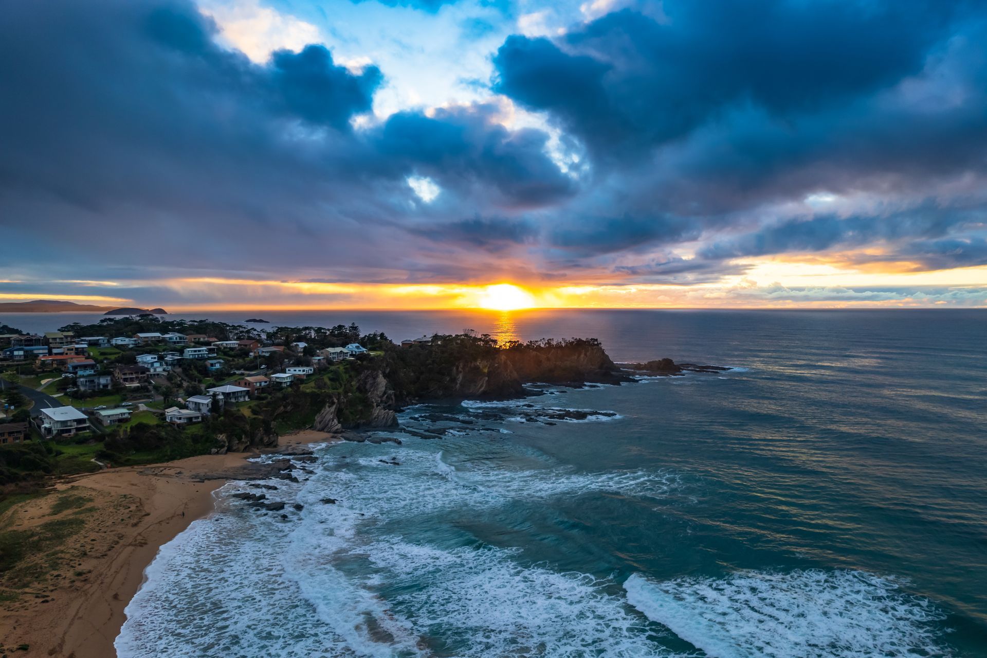 Sunset Over a Coastal Town With Waves — JLH Plumbing, Gas & Roofing in Batemans Bay, NSW