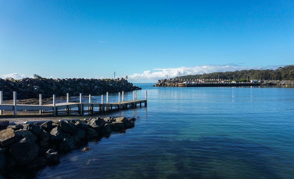 Wooden Pier Extends Into Calm Blue Water — JLH Plumbing, Gas & Roofing in Ulladulla, NSW