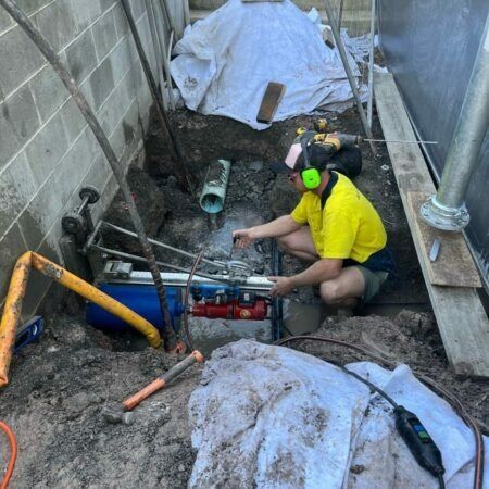 Man Doing a Work on Green Pipe — JLH Plumbing, Gas & Roofing in Vincentia, NSW