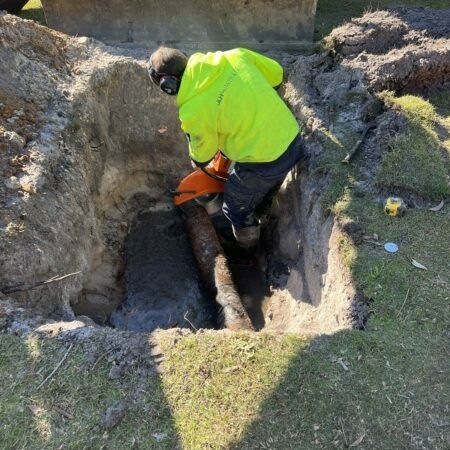 Worker Working on Rusty Pipe — JLH Plumbing, Gas & Roofing in Kiama, NSW