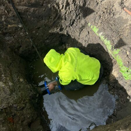 Man Working on Blue Pipe — JLH Plumbing, Gas & Roofing in Shellharbour, NSW
