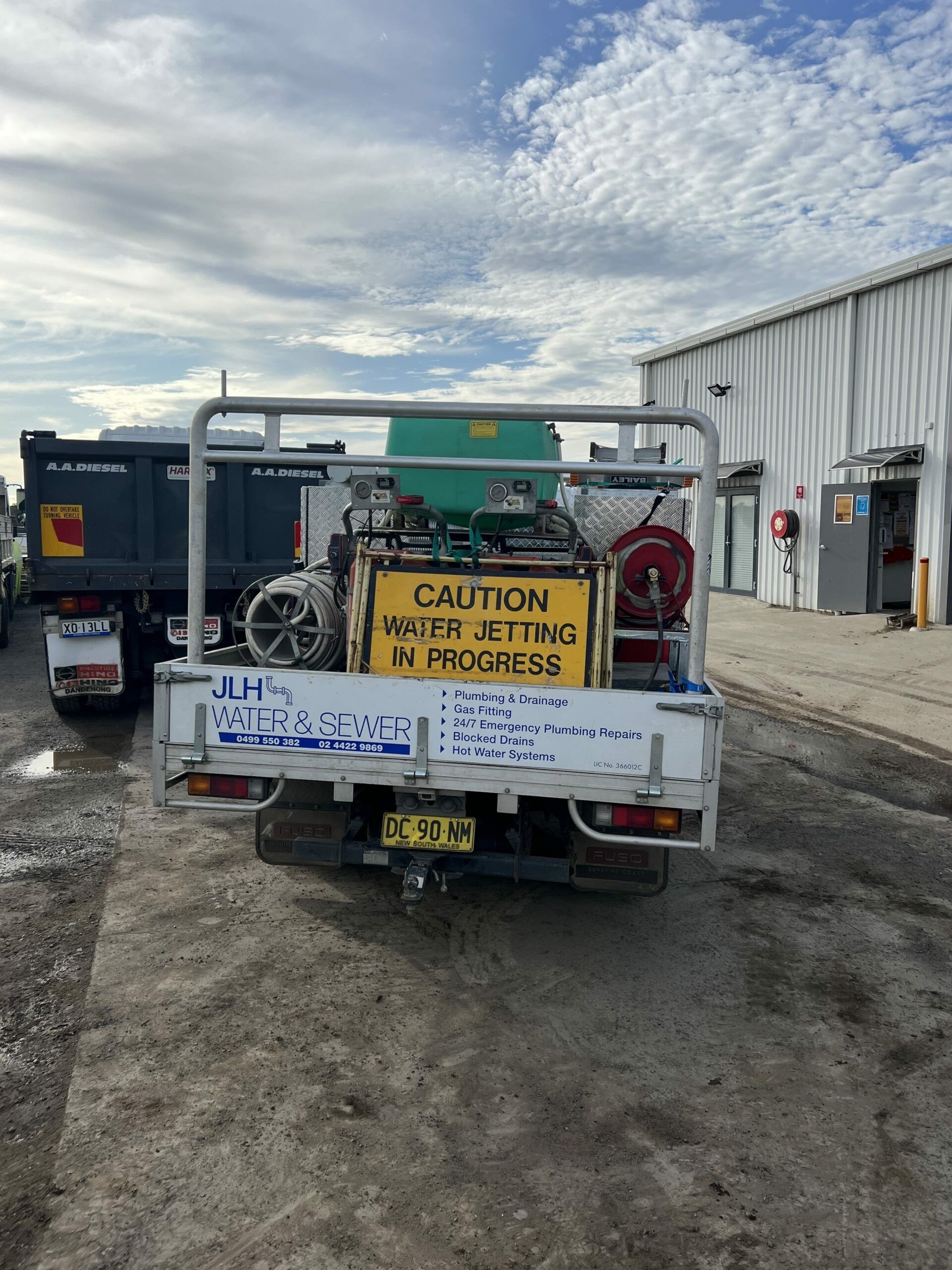 Rear View of a Water Jetting Truck With Warning Sign — JLH Plumbing, Gas & Roofing in South Nowra, NSW