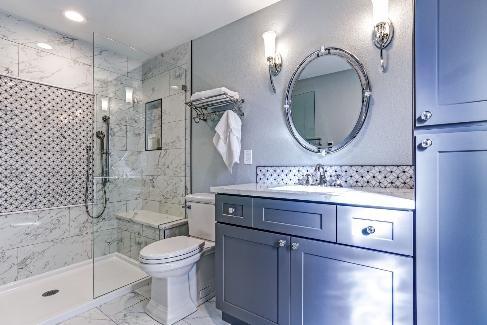 A bathroom with a toilet , sink , mirror and walk in shower.