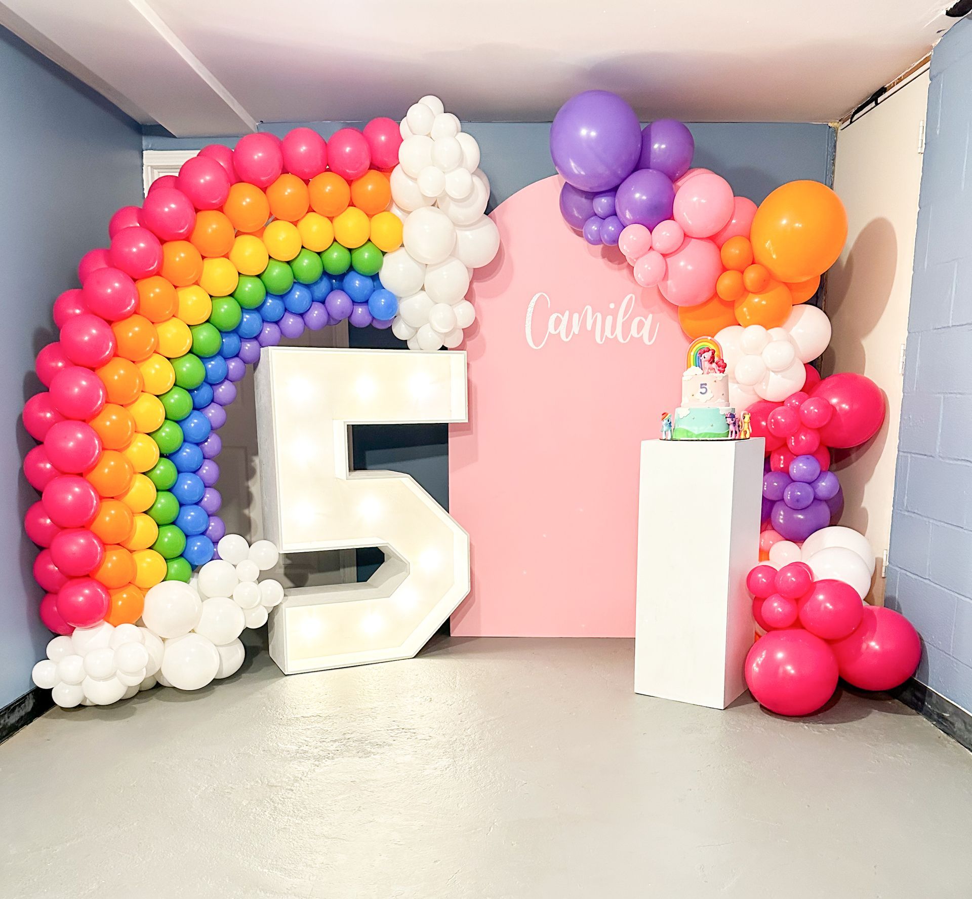 A room decorated with balloons and a large number 5