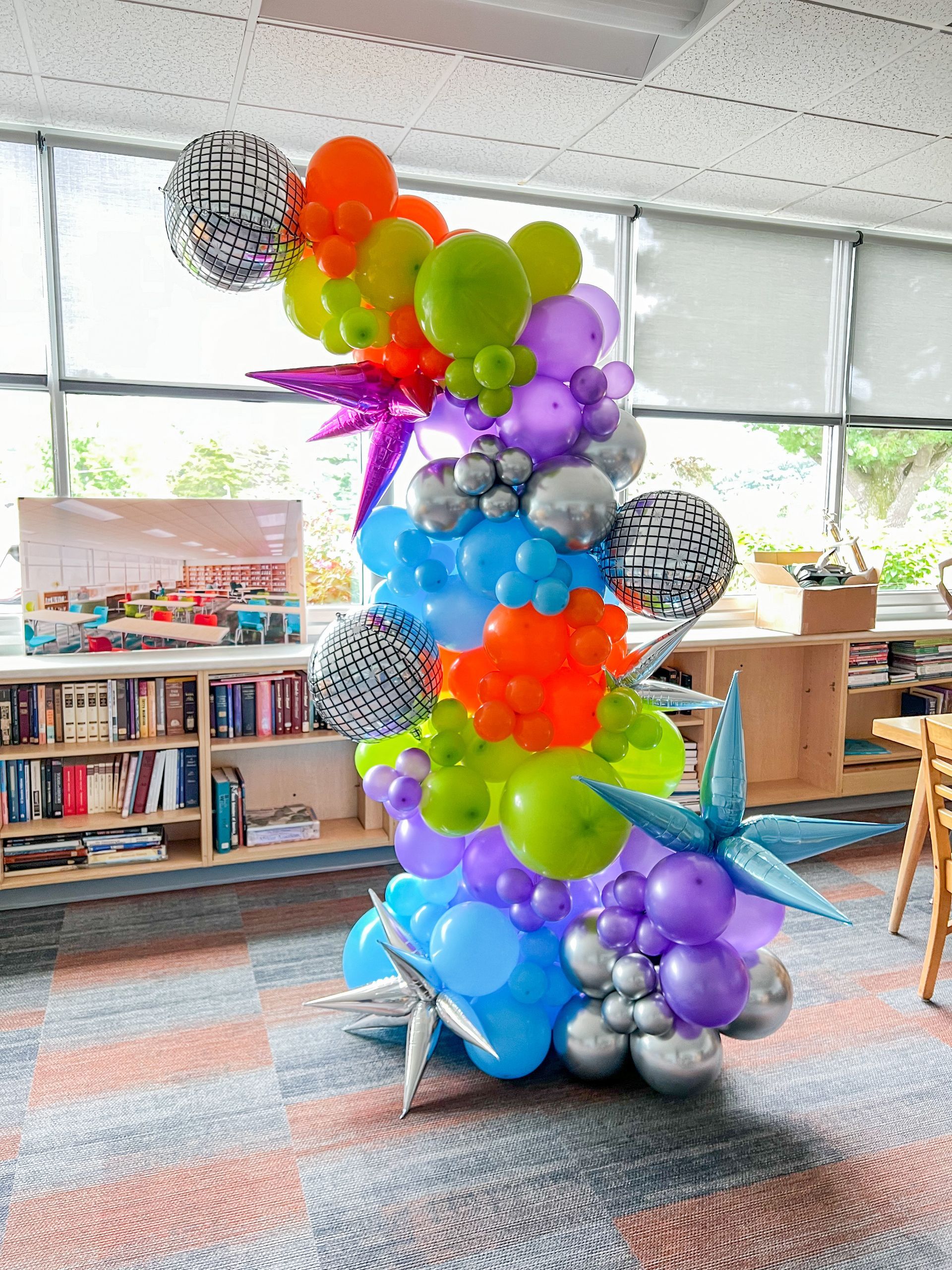 A bunch of balloons are stacked on top of each other in a room.