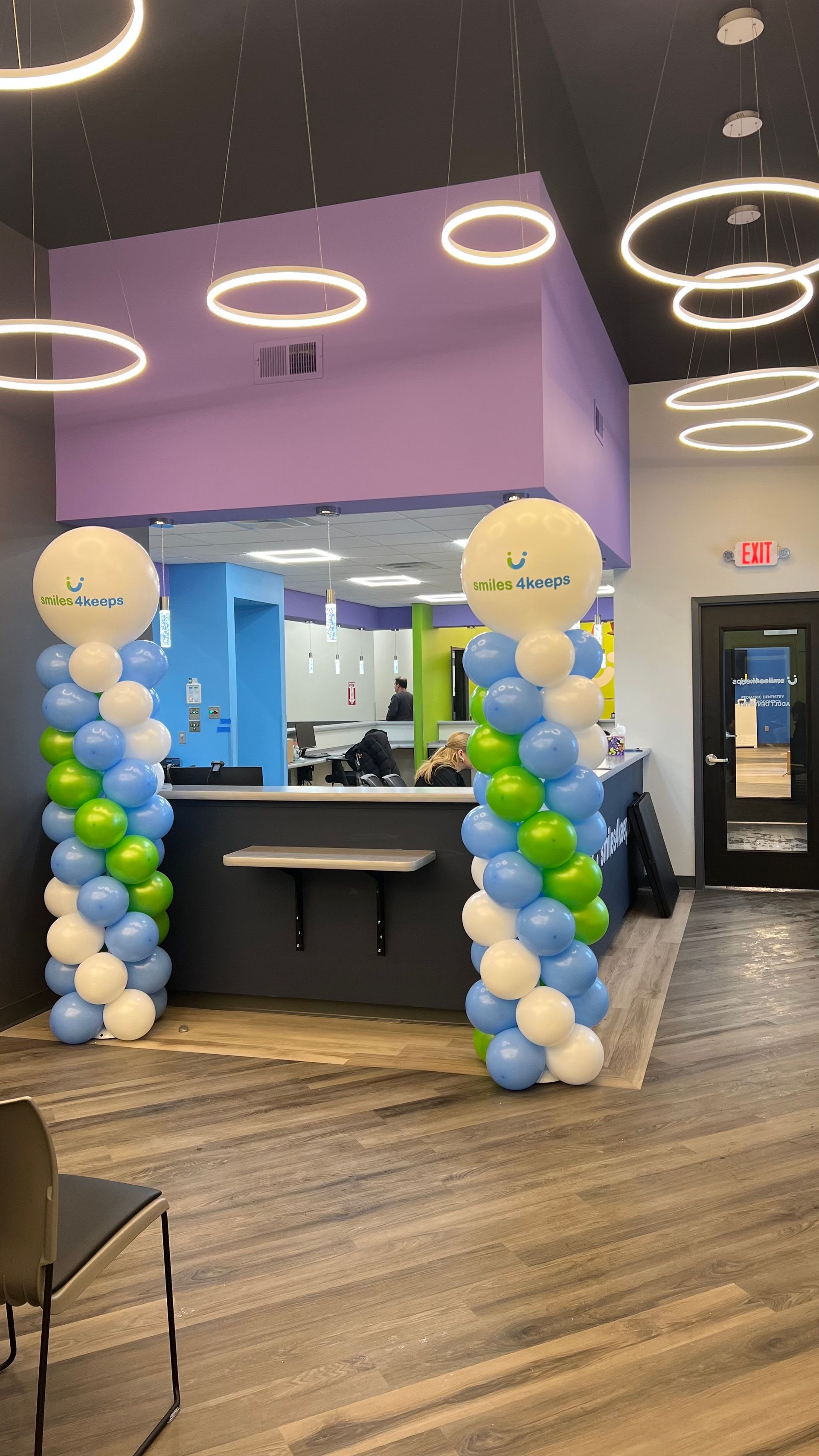 A dental office with balloons in front of a counter.