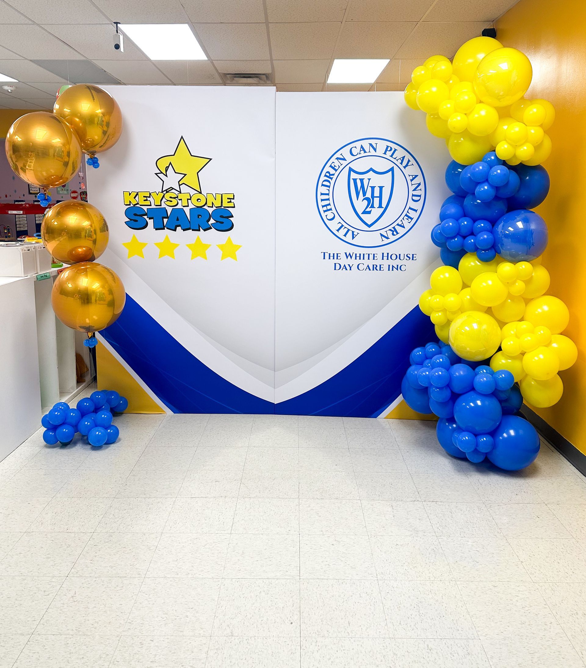 A room with balloons and a sign that says