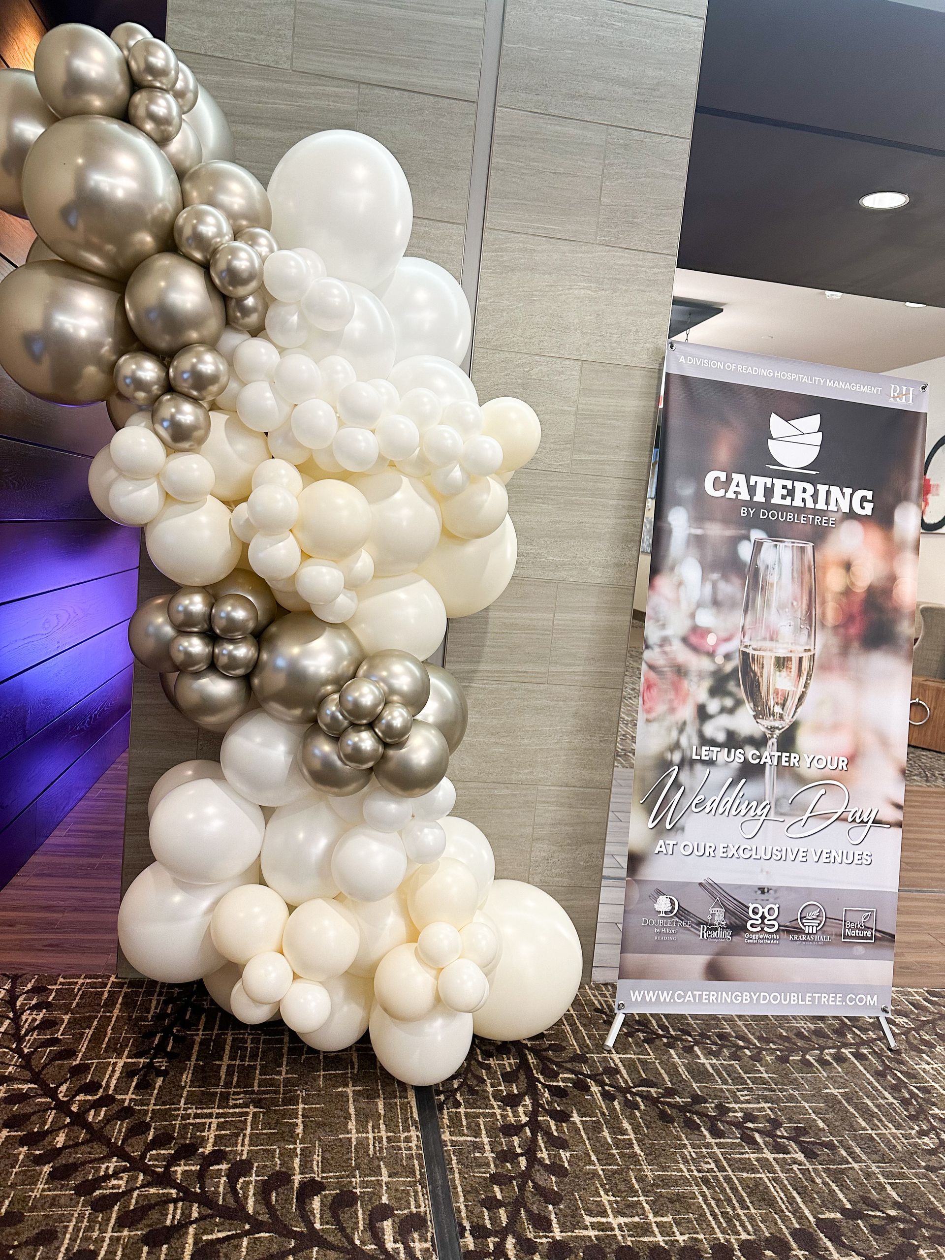 A bunch of balloons are sitting next to a sign that says catering.