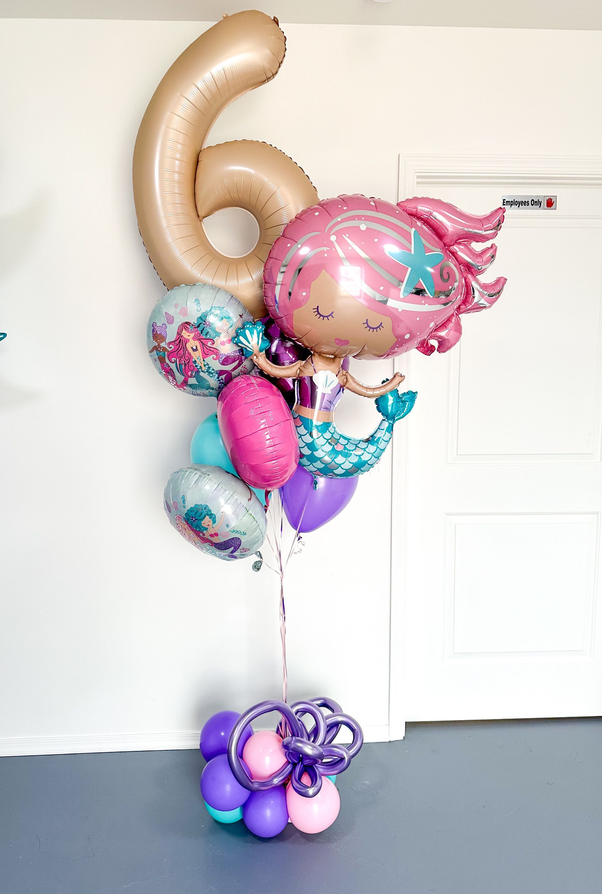 A helium bunch of balloons with a mermaid balloon and a number 6 balloon