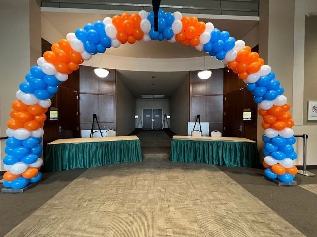 A blue and orange balloon arch in a hallway