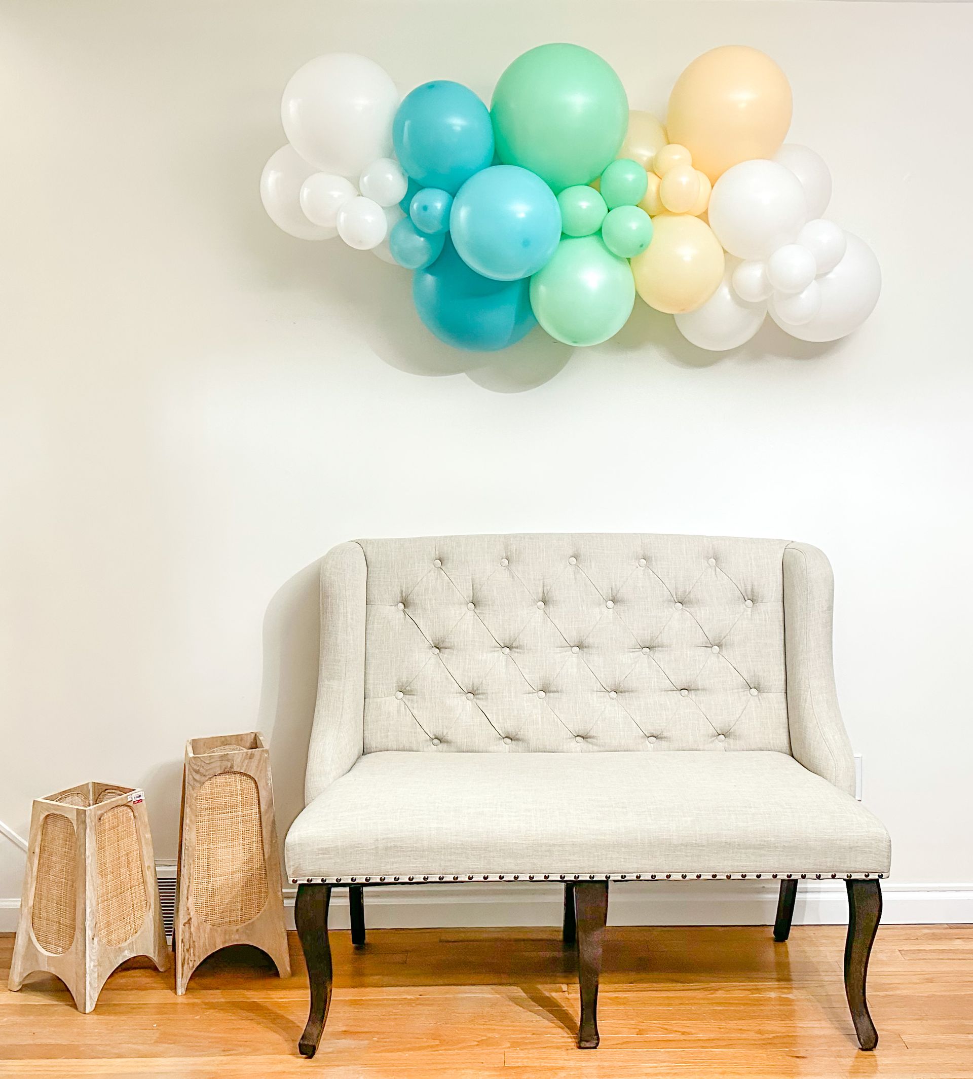 A living room with a couch and balloons on the wall.