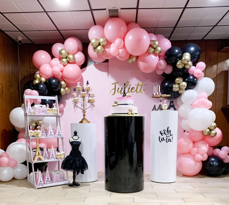 A room decorated with a pink and black balloon arch for Juliette 's birthday.