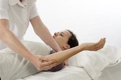 Patient lying on a bed having treatment on her arm