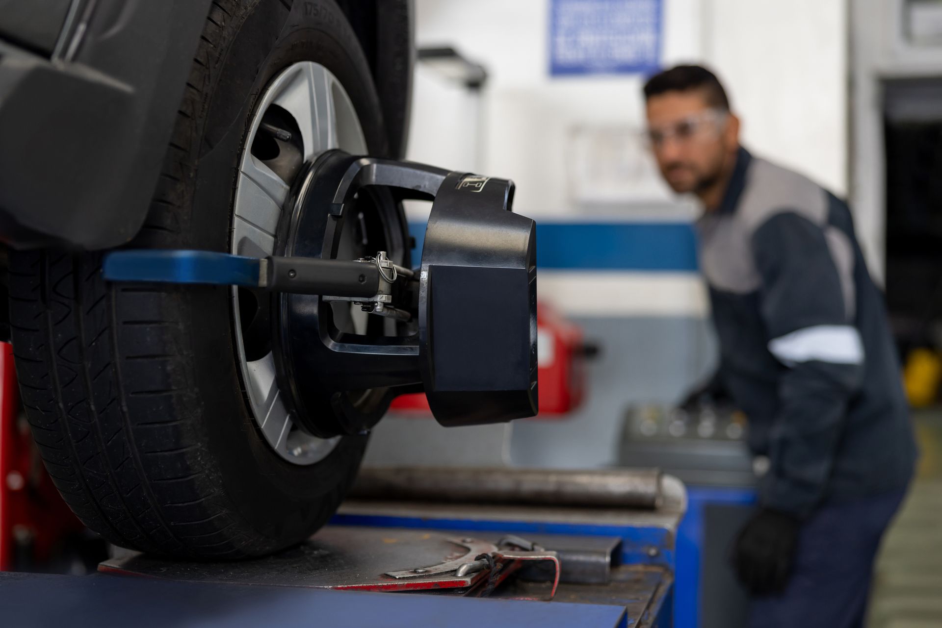 A man is working on a car wheel in a garage.