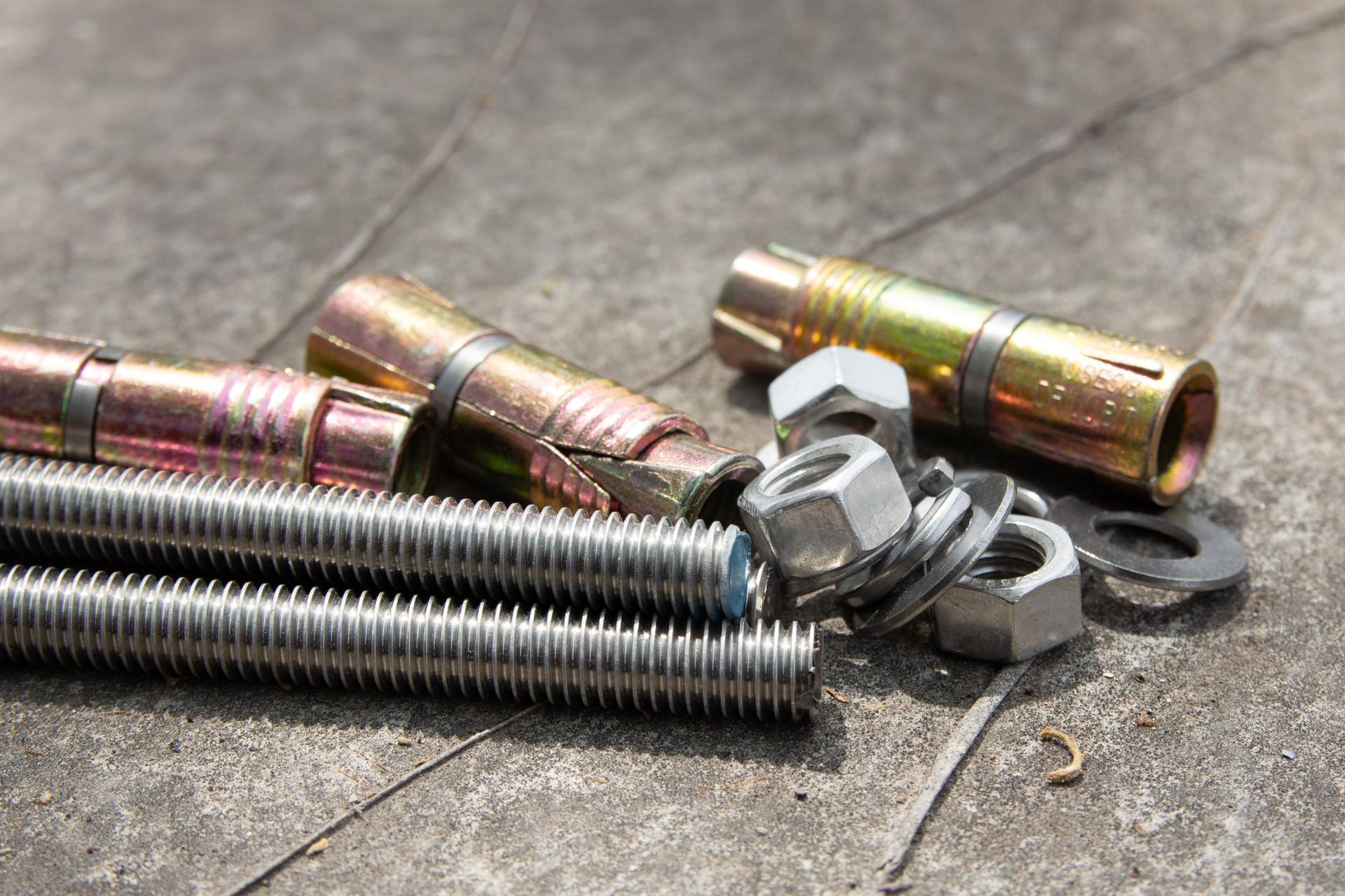 A bunch of nuts and bolts are laying on the ground — Fullerton's Plumbing Manufacture In Woree, QLD