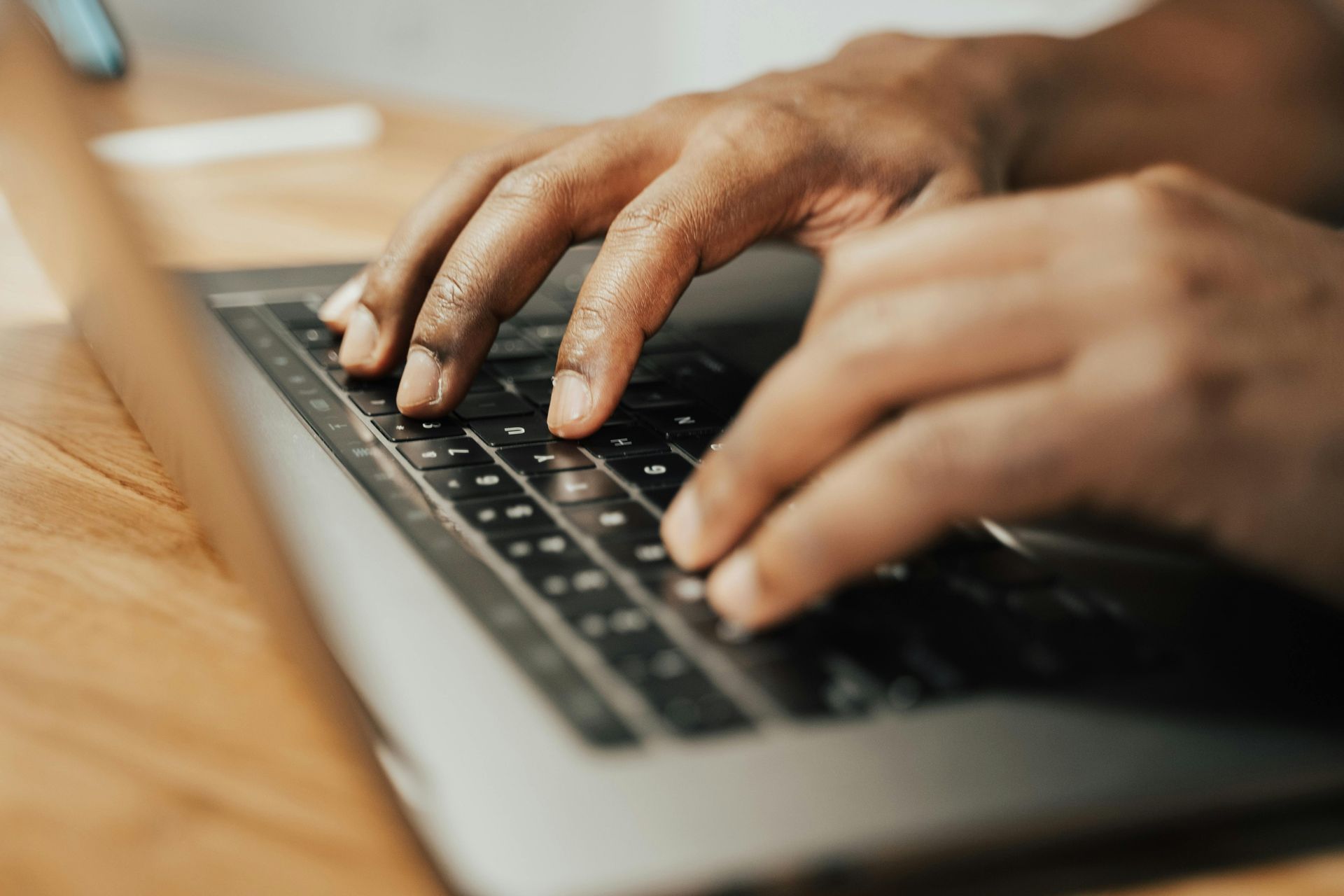 Hands typing on a laptop keyboard; close-up shot.