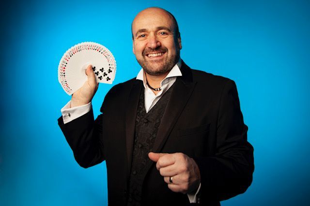 A bride and groom are posing for a picture with a man in a suit.