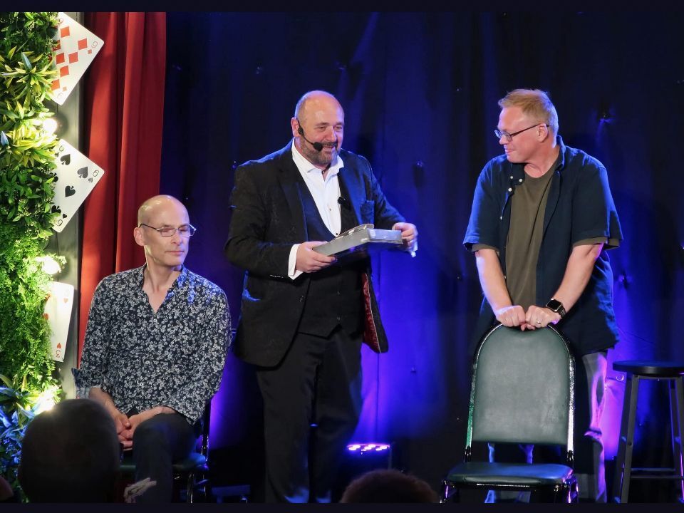 Paul onstage performing magic at a business event in Crewe.