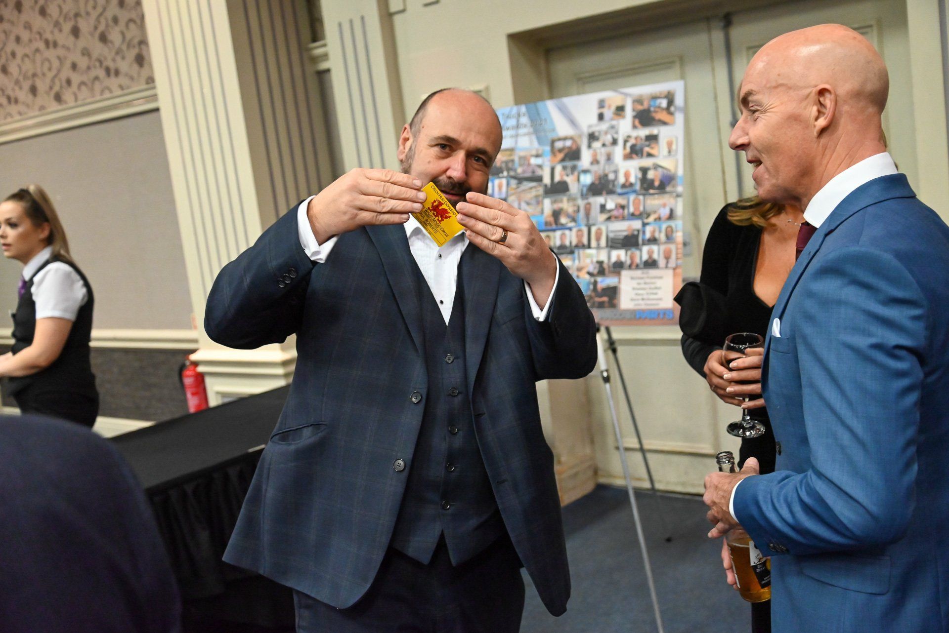 Two men in suits are standing next to each other in a room.