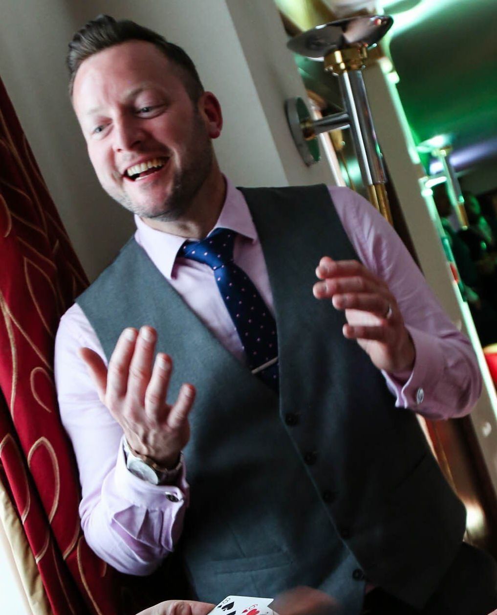 A best man performing a magic trick during his wedding speech, taught by Paul Roberts, captivating the audience at a Wrexham wedding.