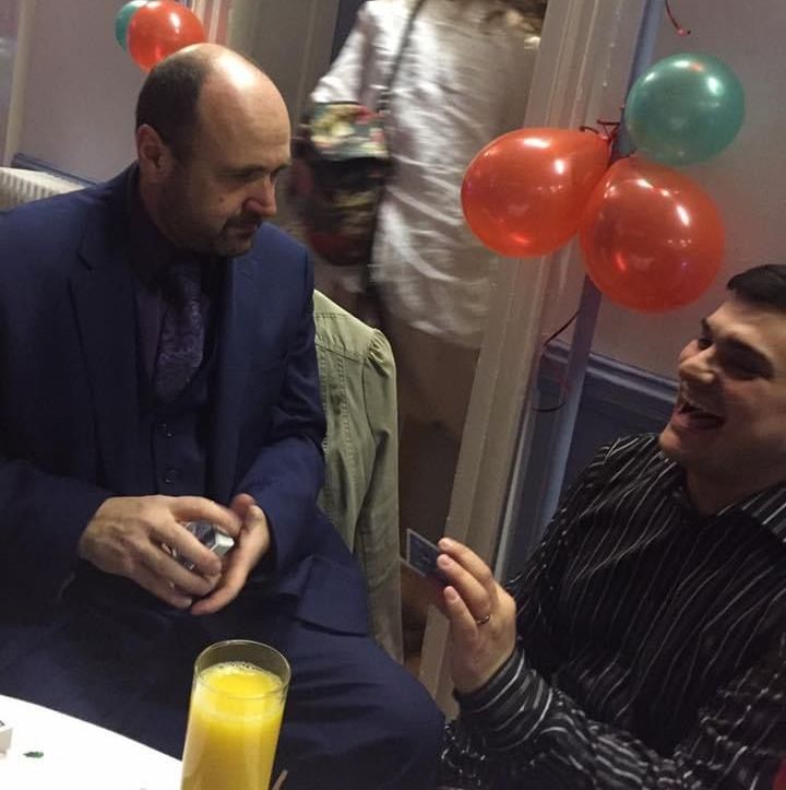 Paul Roberts, a professional magician, teaching a student a card trick during a private party magic lesson in Wrexham, North Wales.