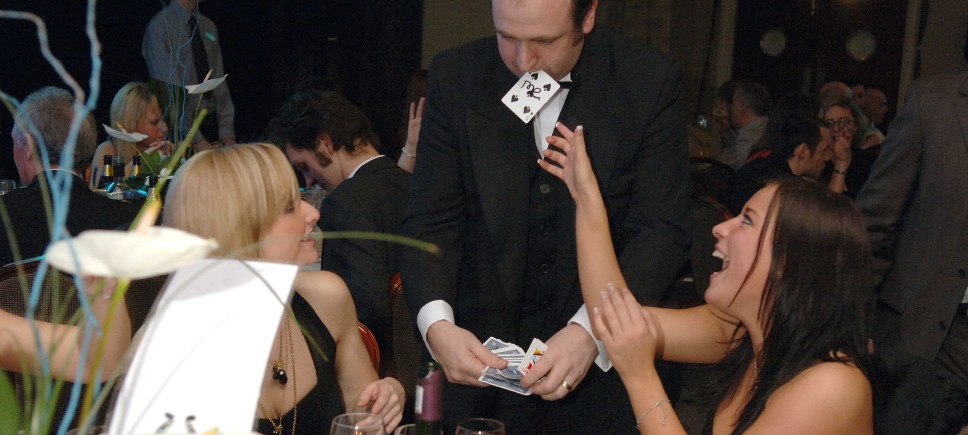 Magician Paul Roberts performs at a celebration in Blackpool., the faces of the audience all look thrilled and amazed.  
