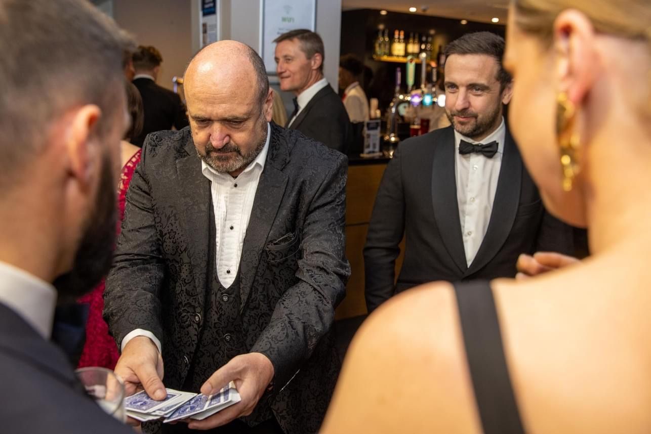 Corporate Magician performing card tricks for a Stoke audience.
