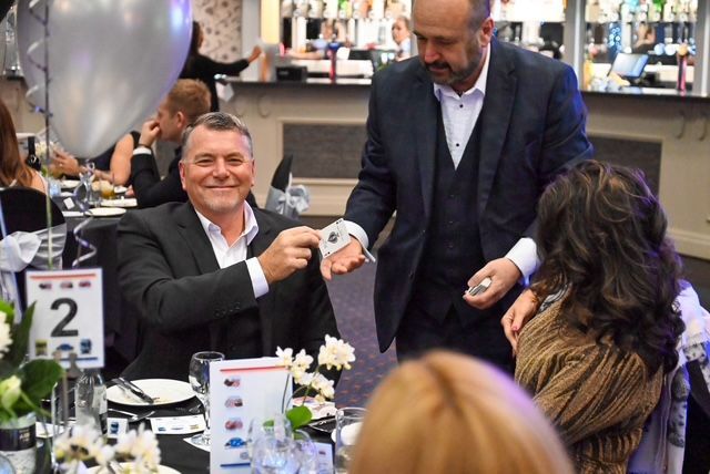 Happy guests at a Christmas bash, enjoying the Magic of Paul Roberts.