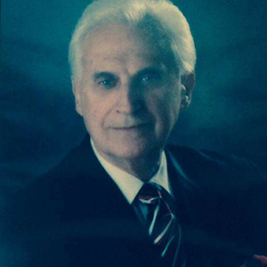 A man in a suit and tie is looking at the camera.