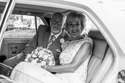 Spirit Wedding Cars | A bride and groom are sitting in the back seat of a car.