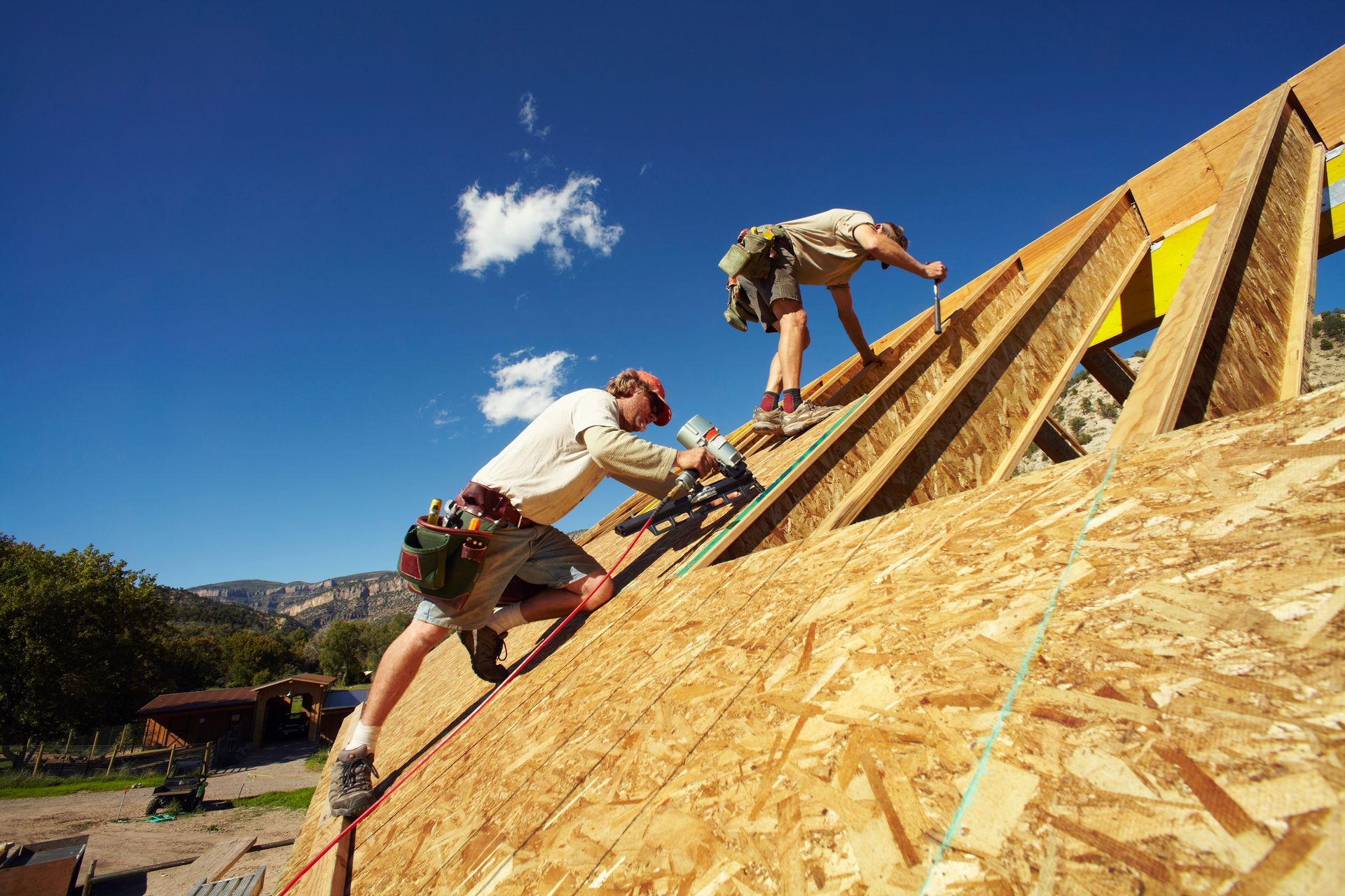 Two roof contractors working on a roof construction.