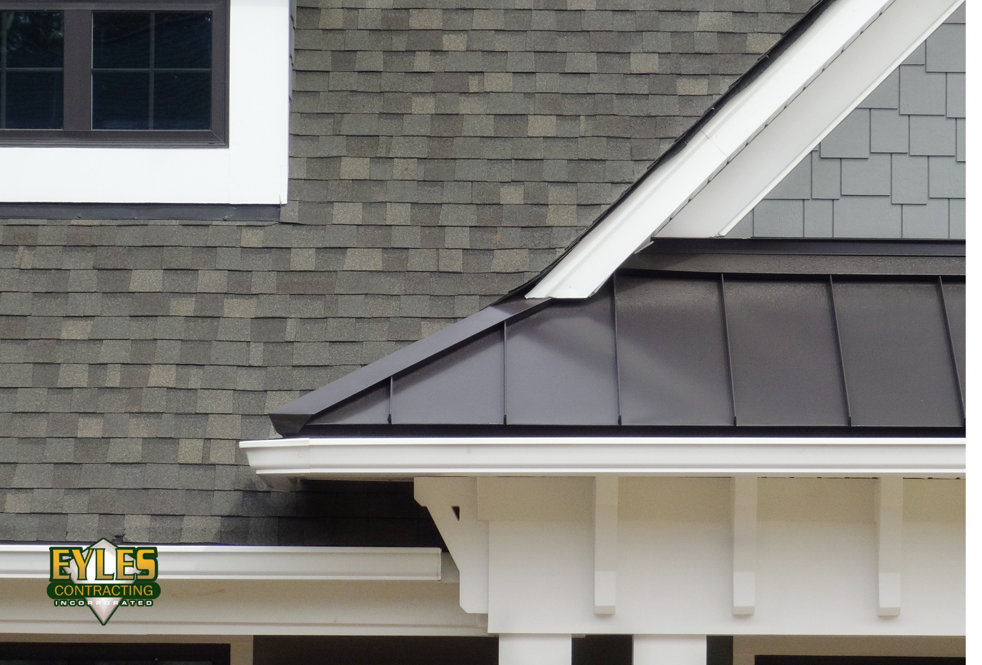 Close-up view of a residential home featuring a roof with architectural shingles and metal roofing s