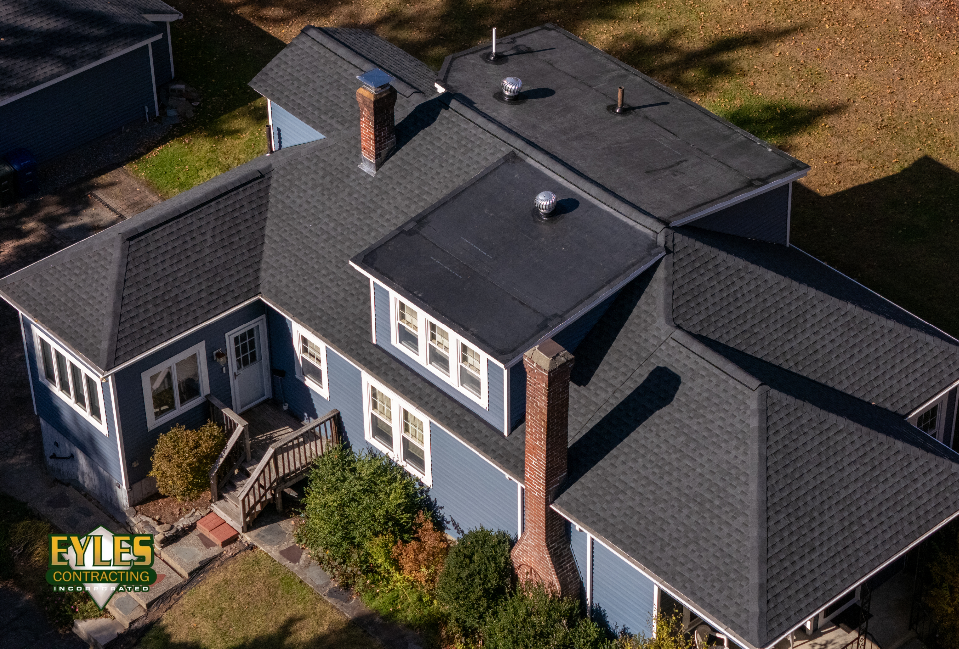 Residential home featuring architectural shingles and a rubber membrane roofing system