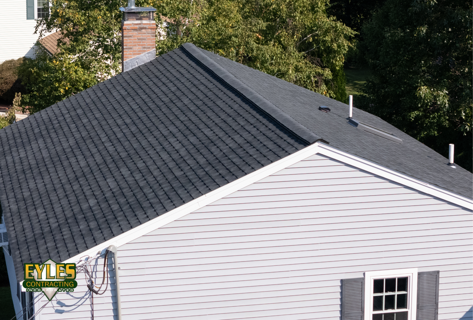 Residential roof with architectural shingles and ridge ventilation along the peak.