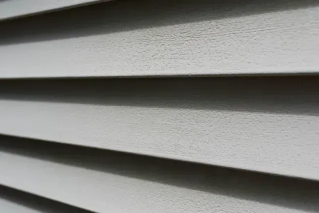 A close up of a white vinyl siding on a house.