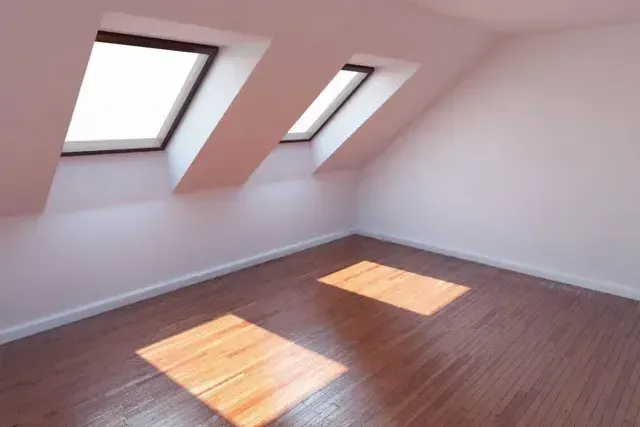 An empty room with two skylights on the ceiling